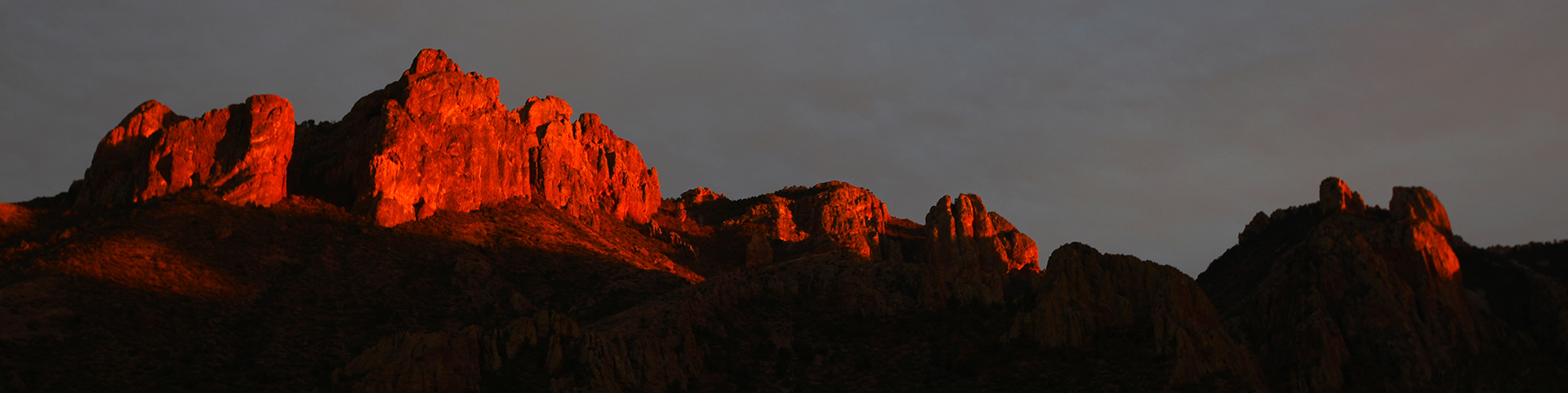 Rugged mountain ridge illuminated by red-orange sunset light