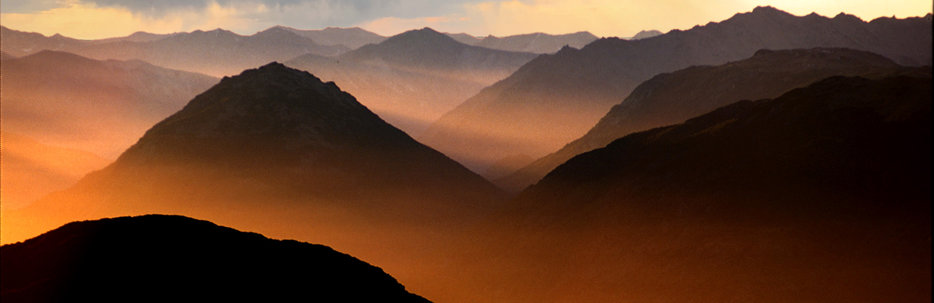 Layered mountain ranges at sunrise